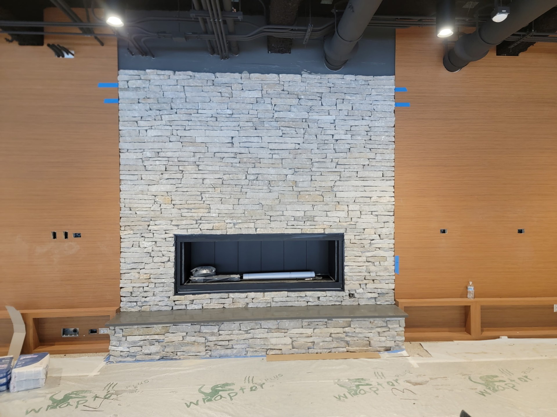 Floor-to-ceiling ledger stone fireplace with linear firebox