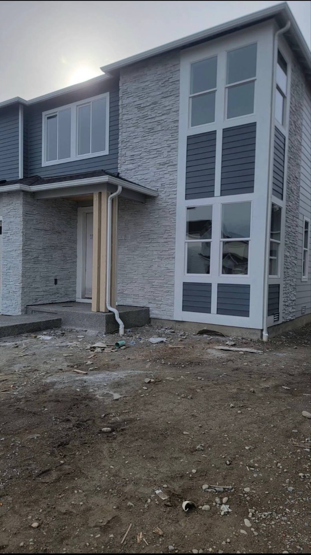 Modern two-story home with white stacked stone veneer facade