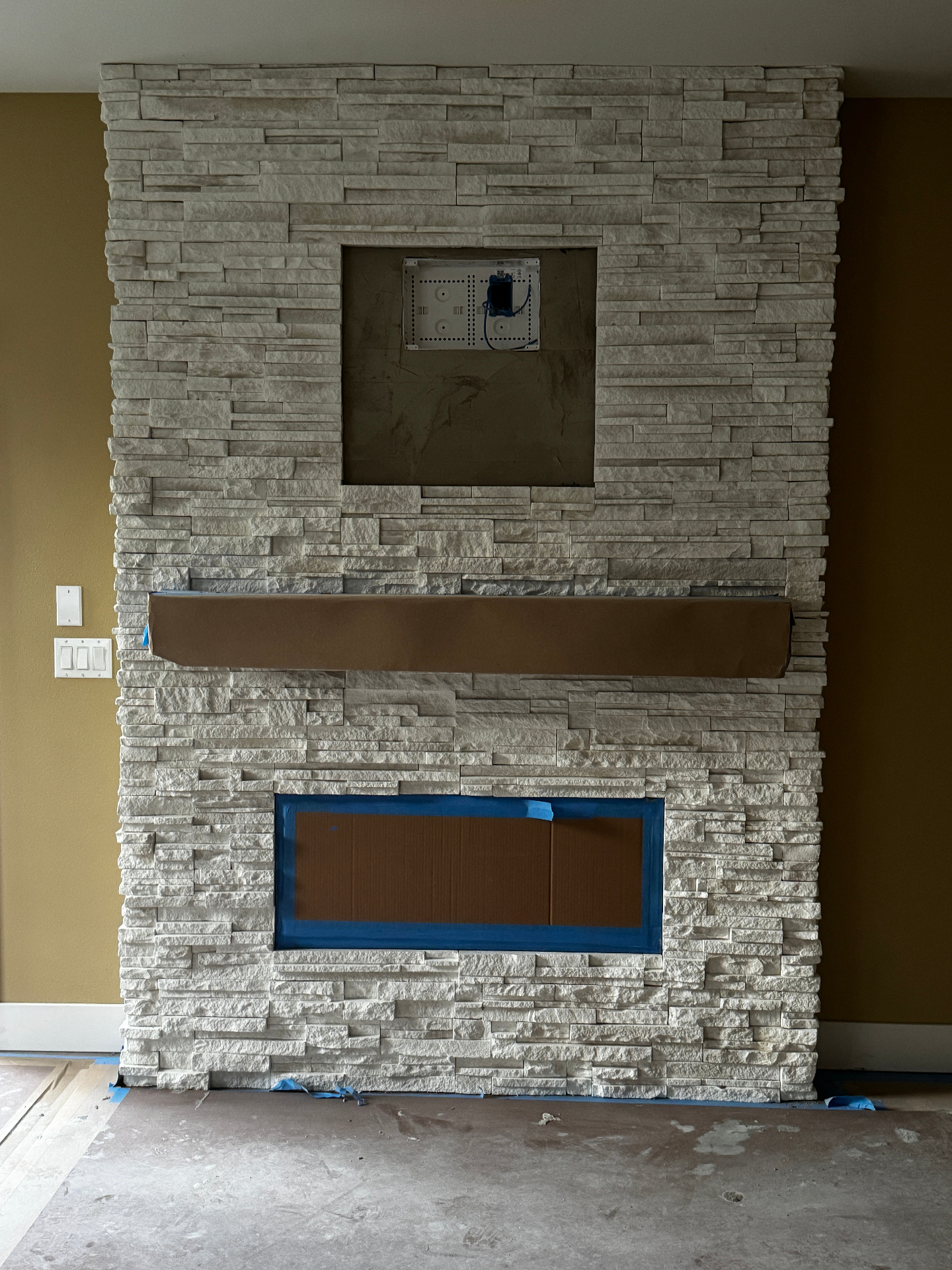 Floor-to-ceiling white stacked stone veneer fireplace
